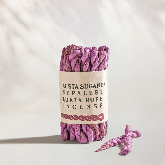 Austa Suganda Lokta Rope Incense Bundle: lilac twisted rope incense in a kraft paper band, two loose ropes beside it.