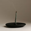 Incense stick with smoke on a clay holder