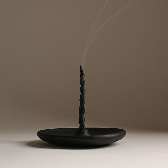 Rope incense stick on a clay plate