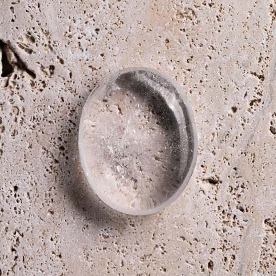 Clear Quartz stone object on a textured surface