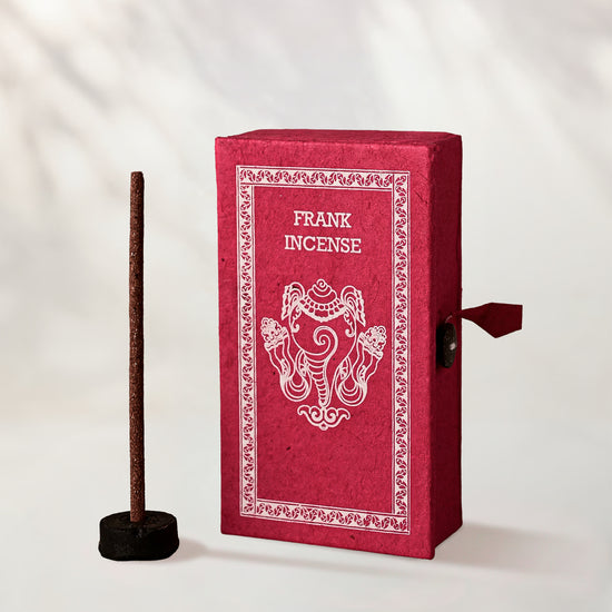 Frankincense Incense Sticks, box of 40: red handmade paper Stupa box with an elephant motif beside one stick in a small holder.