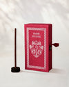 Frankincense Incense Sticks, box of 40: red handmade paper Stupa box with an elephant motif beside one stick in a small holder.