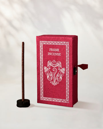 Frankincense Incense Sticks, box of 40: red handmade paper Stupa box with an elephant motif beside one stick in a small holder.