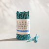 Karma Lokta Rope Incense Bundle: turquoise twisted rope incense in a kraft paper band, two loose ropes beside it.