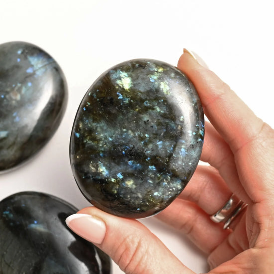 Labradorite_stone_holding_on_hands_332406fe-a3e7-4159-9572-87c97f0c5419 - Maison Éthérique