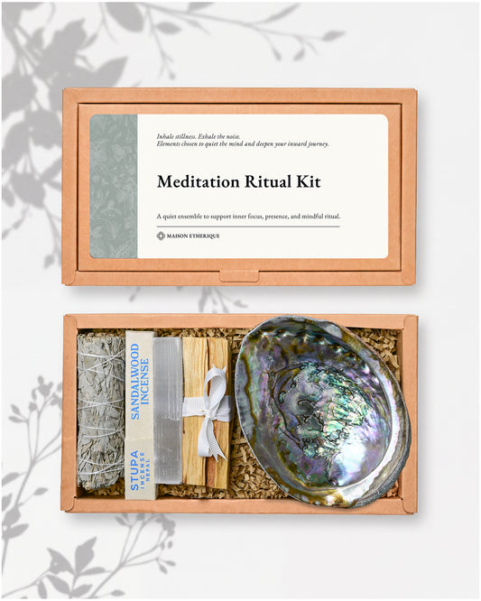 Meditation Ritual Kit by Maison Etherique , presented in a light box with its lid shown above and the open box below. The kit includes a white sage bundle wrapped in a paper sleeve, a wooden incense stick holder with incense sticks, and a large iridescent abalone shell.