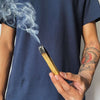Load image into Gallery viewer, A man holding a burned Palo Santo Stick 