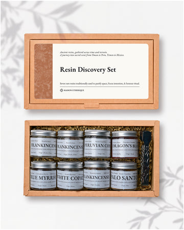 Resin Discovery Kit: kraft box lid above the open box with eight small labelled jars of resin and a pair of metal tongs.