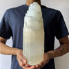 A man holding A Selenite Crystal Tower - 30cm 