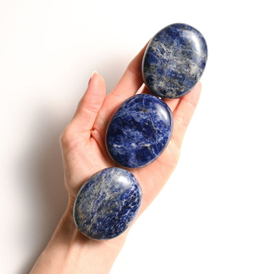 Hand holding three Sodalite Palm stones
