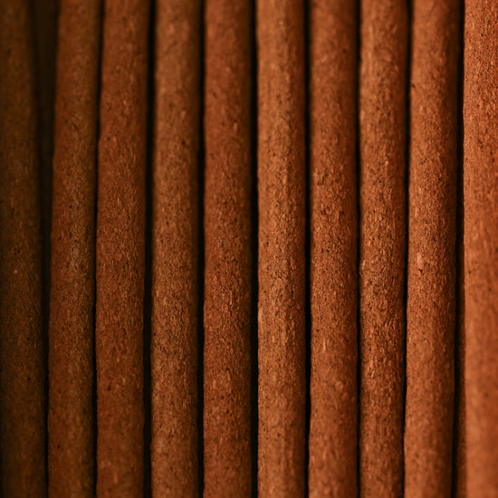 Close view of Himalayan Cedar incense sticks laid side by side, showing their red-brown texture.