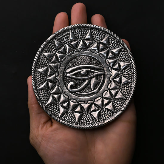 Eye of Horus metal incense holder resting on an open palm.