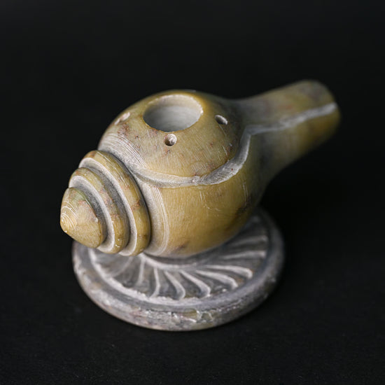 Close view of the Shankh stone incense holder, showing the carved spiral and stick holes.