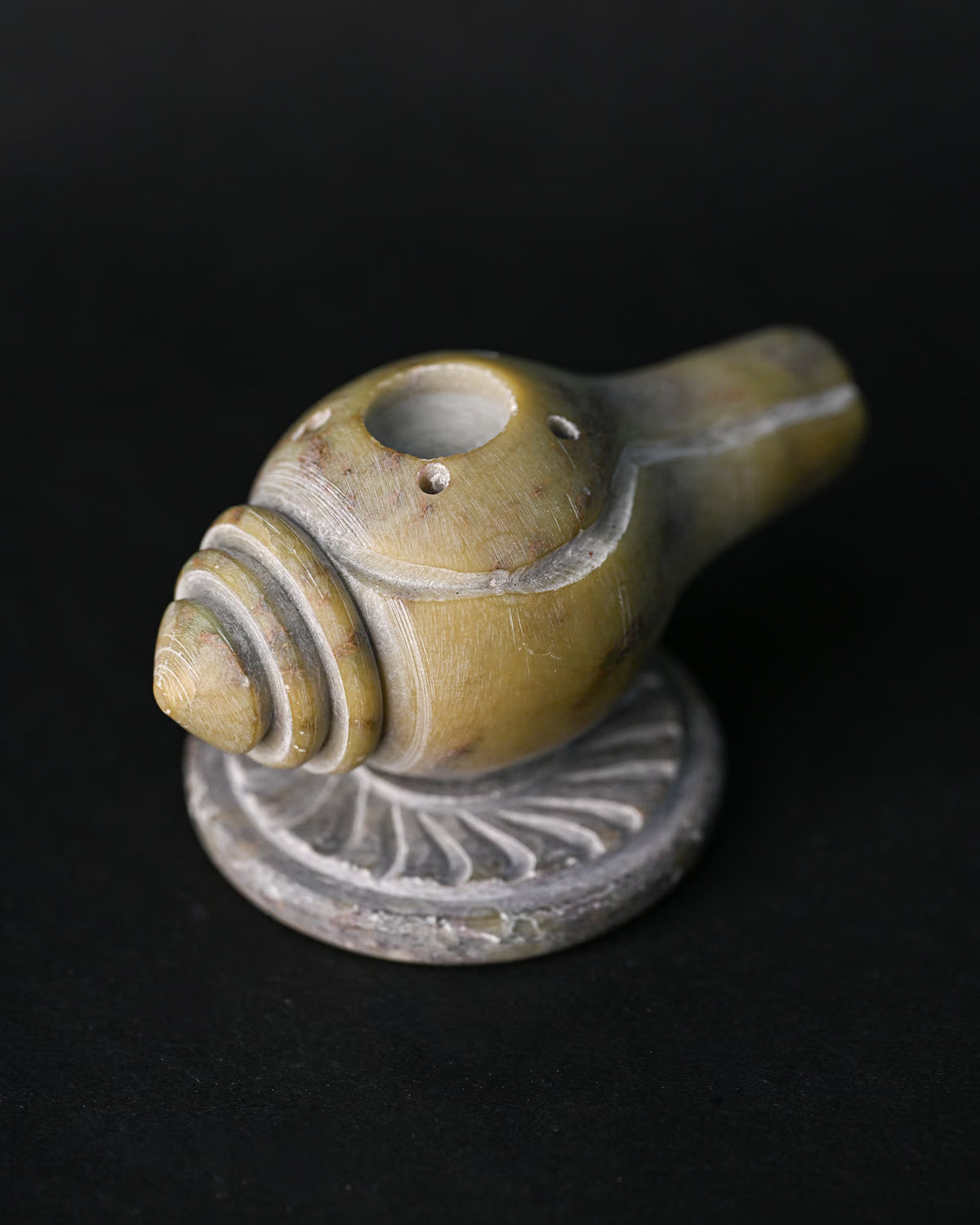 Close view of the Shankh stone incense holder, showing the carved spiral and stick holes.