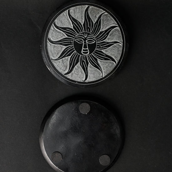 Front and underside of the Soleil Noir stone incense holder, one above the other on a dark background.