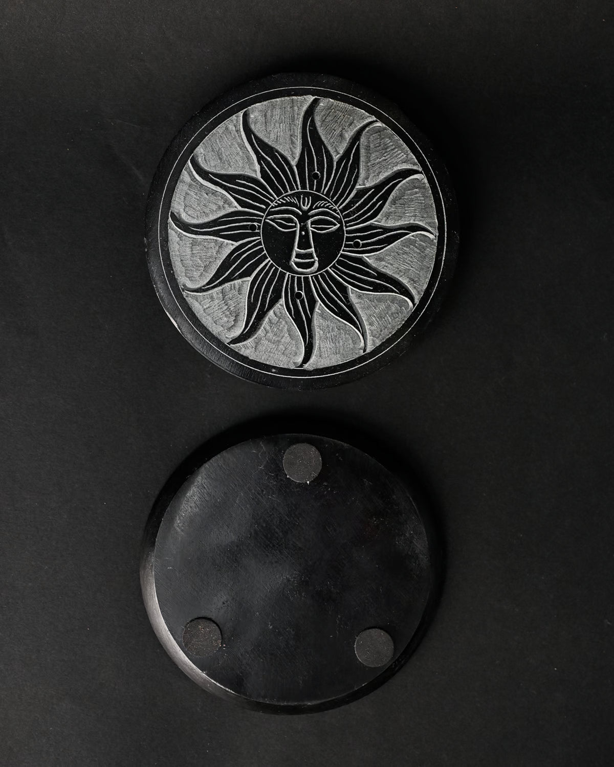 Front and underside of the Soleil Noir stone incense holder, one above the other on a dark background.