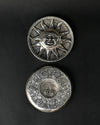 Front and back of the Surya metal incense holder, one above the other on a dark background.