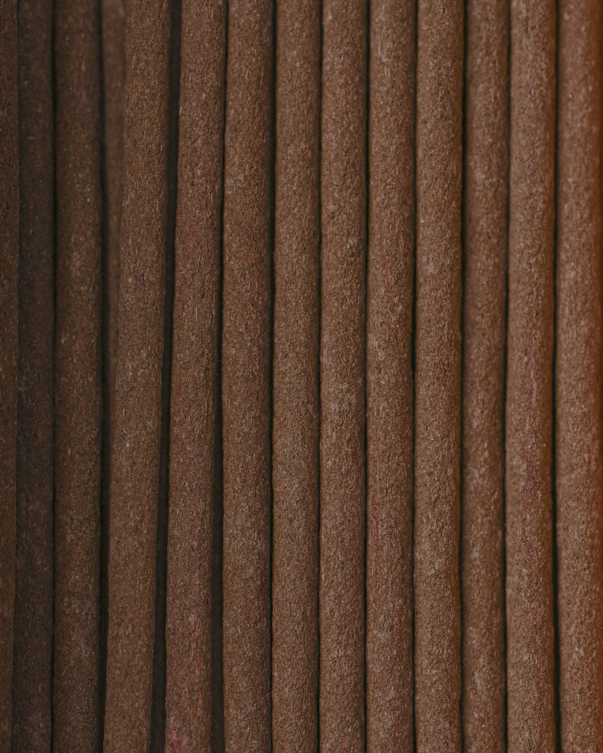 Close view of Na Swa incense sticks laid side by side, showing their brown texture.