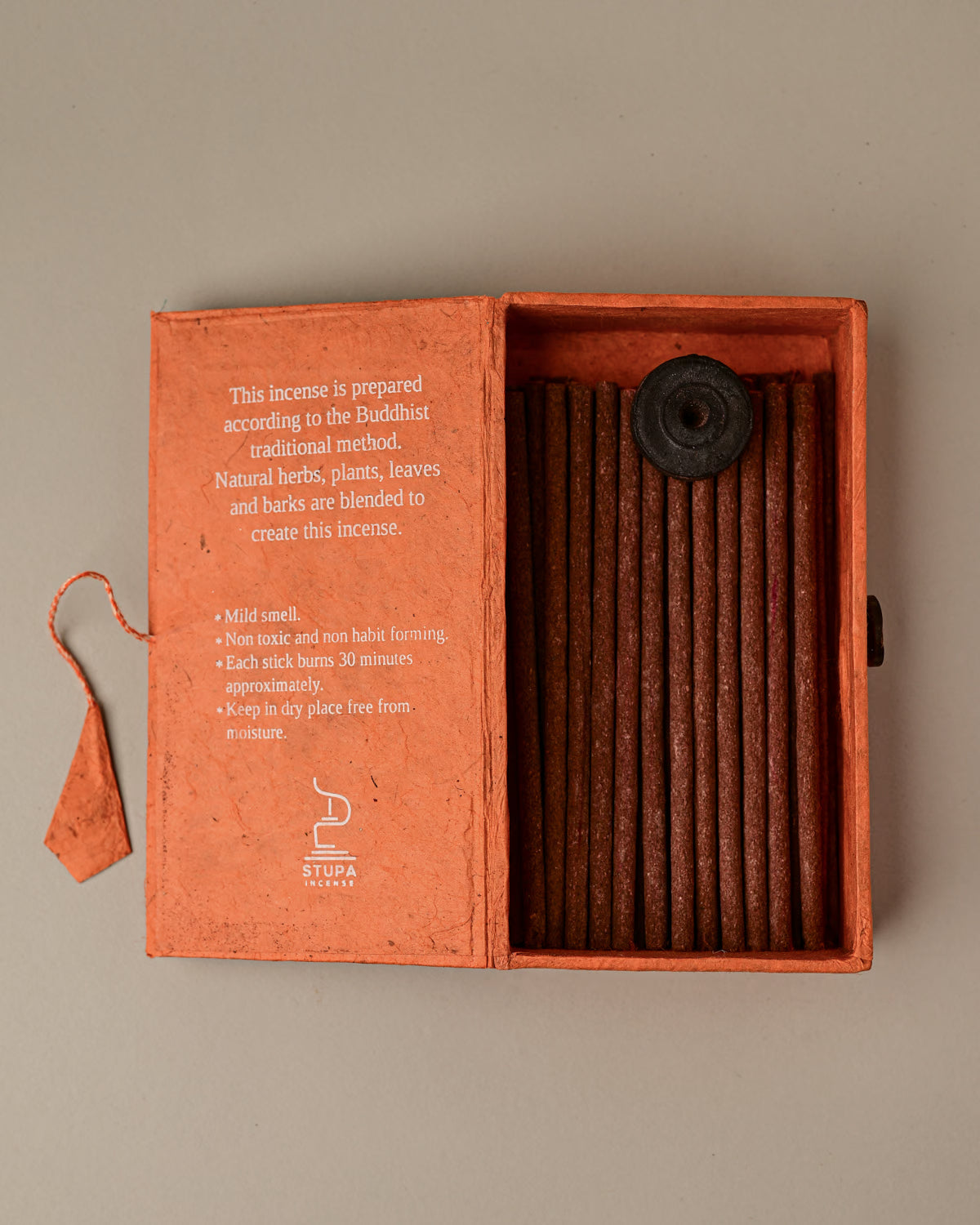 Open orange paper box of Stupa Na Swa incense sticks from Nepal, the sticks and a small holder visible inside.