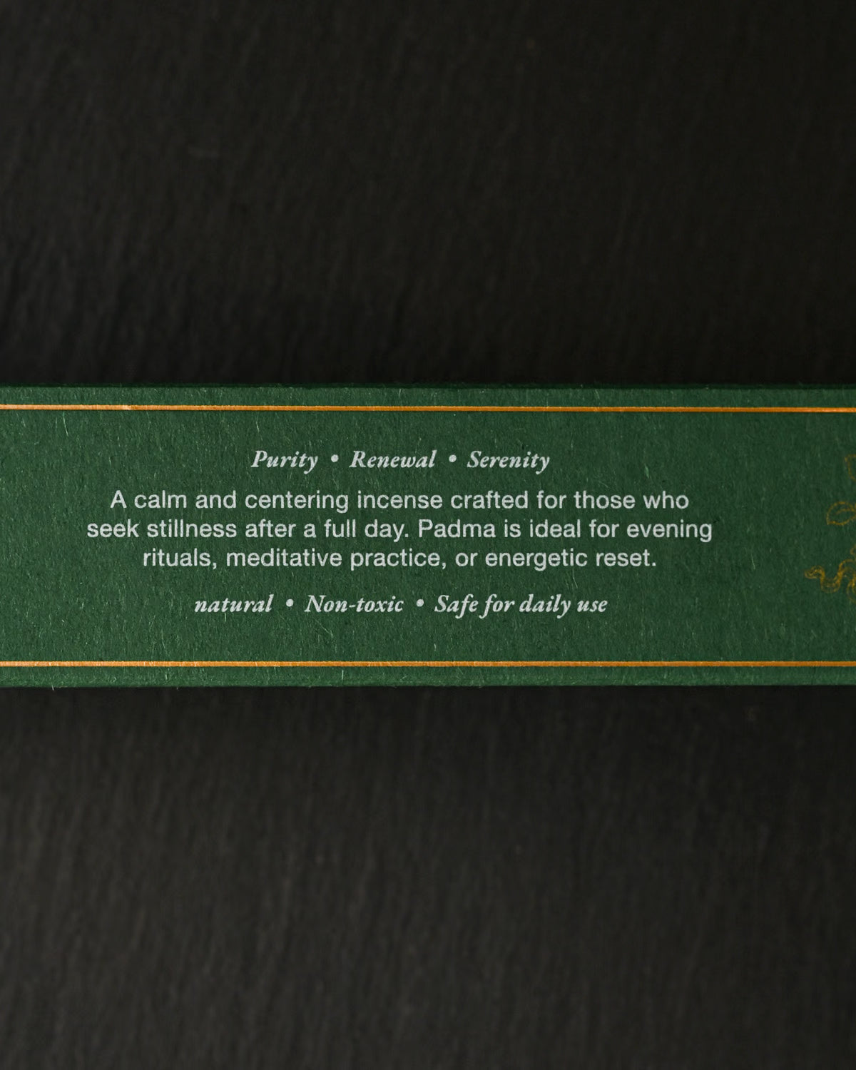 Side of the green Padma Tibetan incense box with printed gold text, on a dark background.