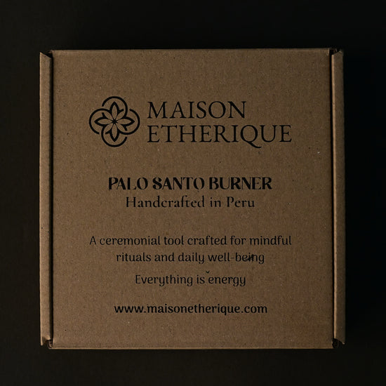 Kraft card box for the Maison Éthérique Palo Santo burner, handcrafted in Peru, on a dark background.