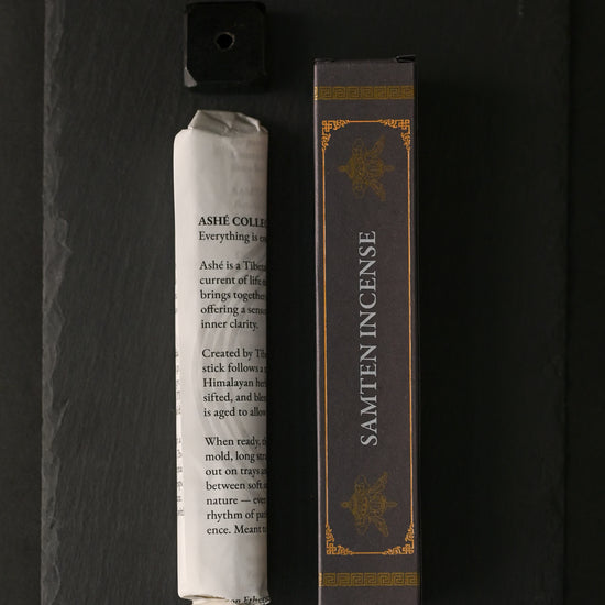 Samten Tibetan incense: paper-wrapped bundle, dark box and small holder laid out on dark slate.