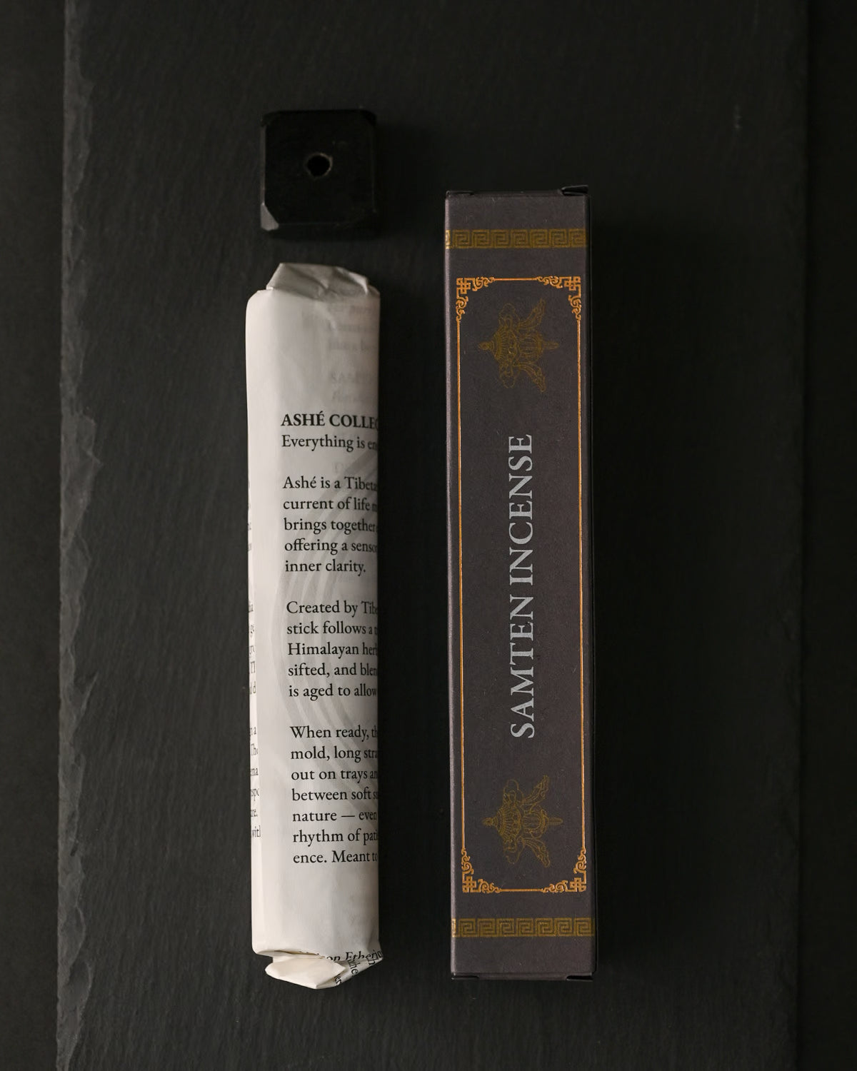 Samten Tibetan incense: paper-wrapped bundle, dark box and small holder laid out on dark slate.