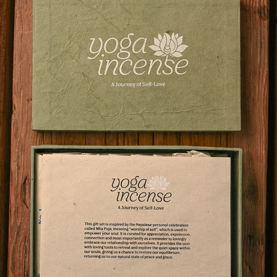 Yoga Incense gift box in green handmade paper, the lid above and the open box with its printed insert below, on a wooden surface.