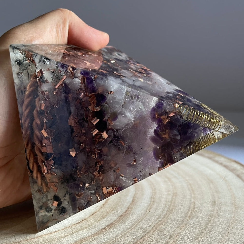 A hand holding Orgonite Pyramid - Balance and Protection