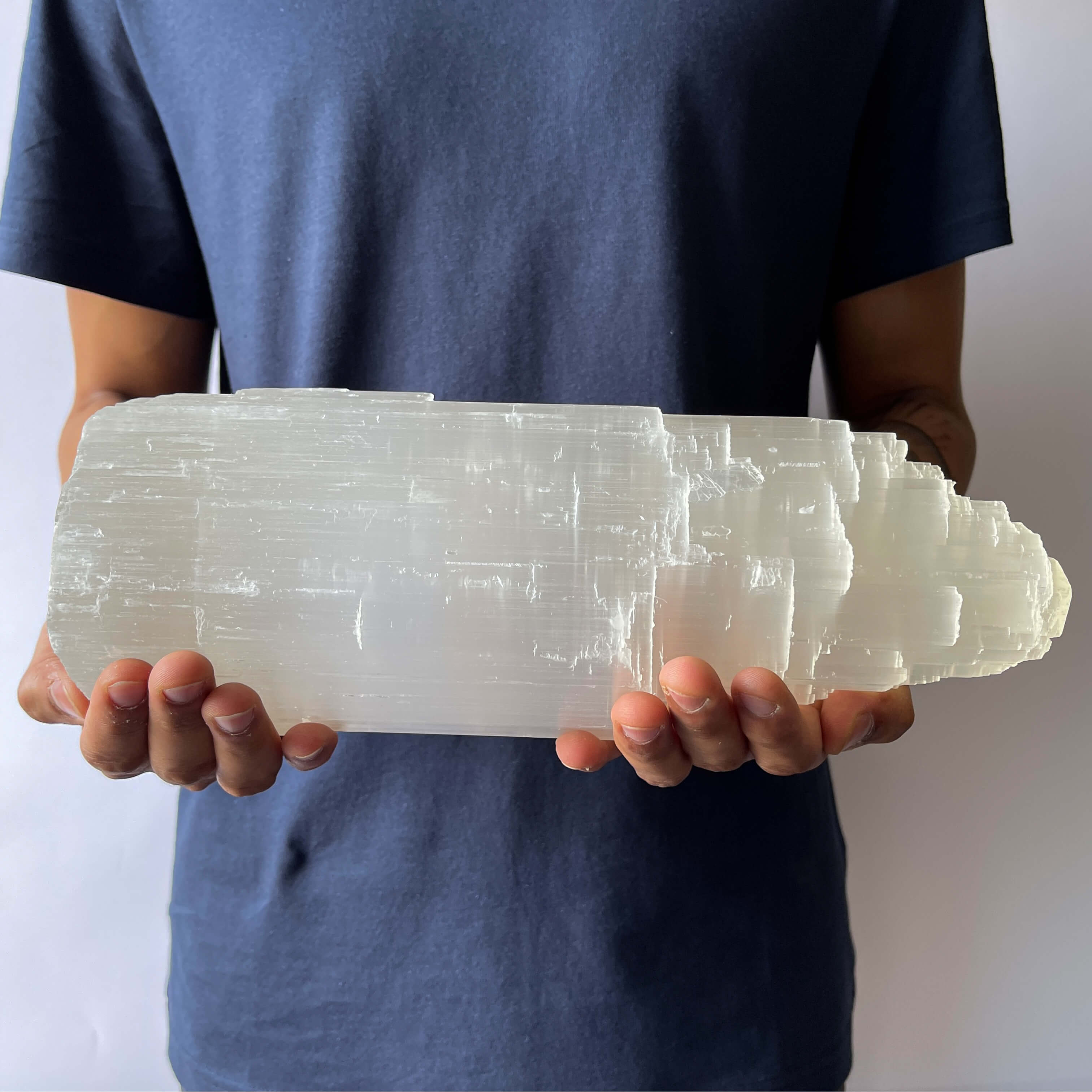 A man showing A Selenite Crystal Tower - 30cm in his hands