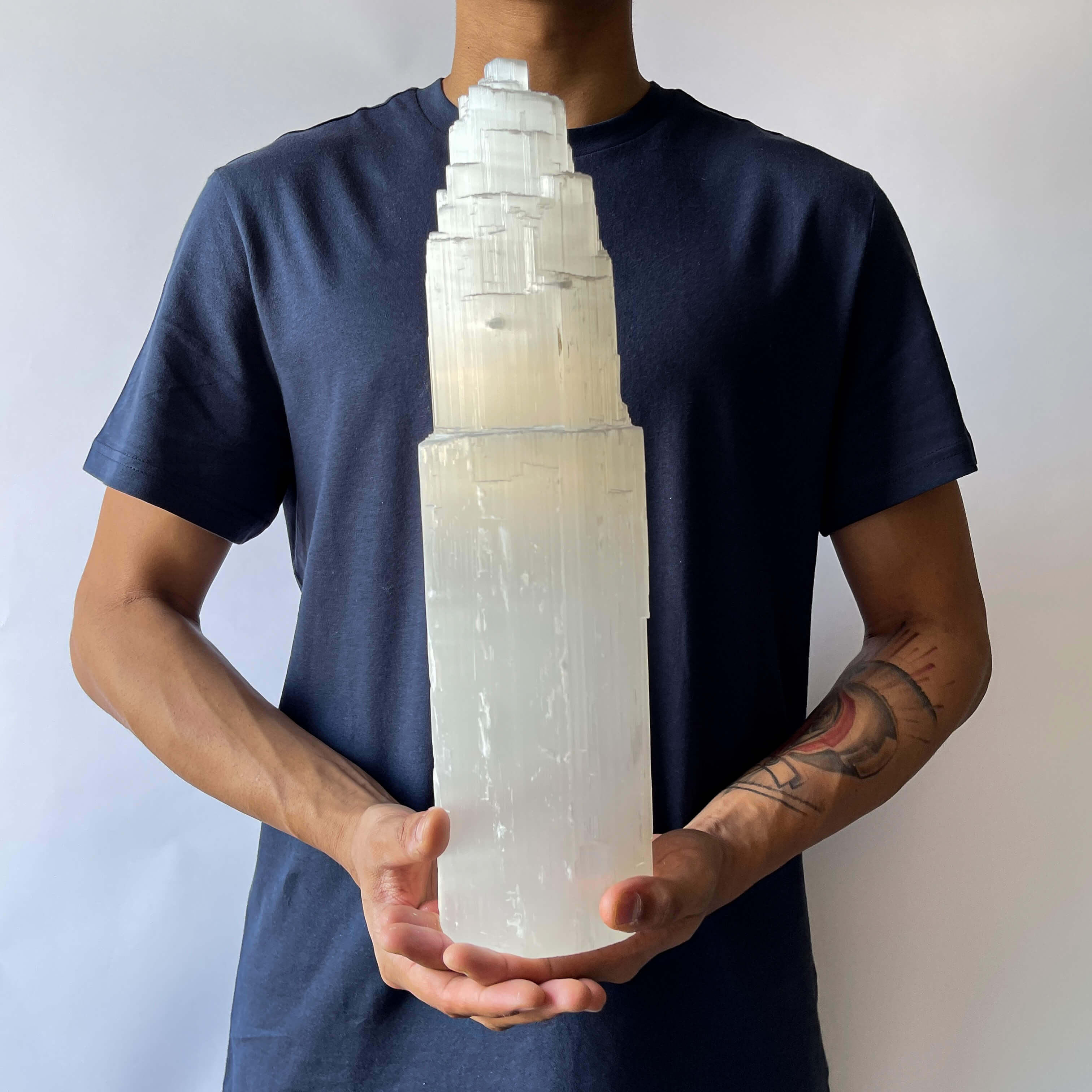 A man holding A Selenite Crystal Tower - 40cm 