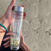 A woman holdig Crystal Bottle with Tumbled Citrine in the beach 