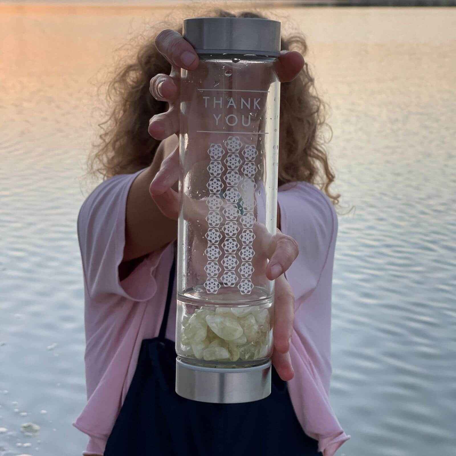 A woman holding a tumbled Citrine Crystal Water Bottle 