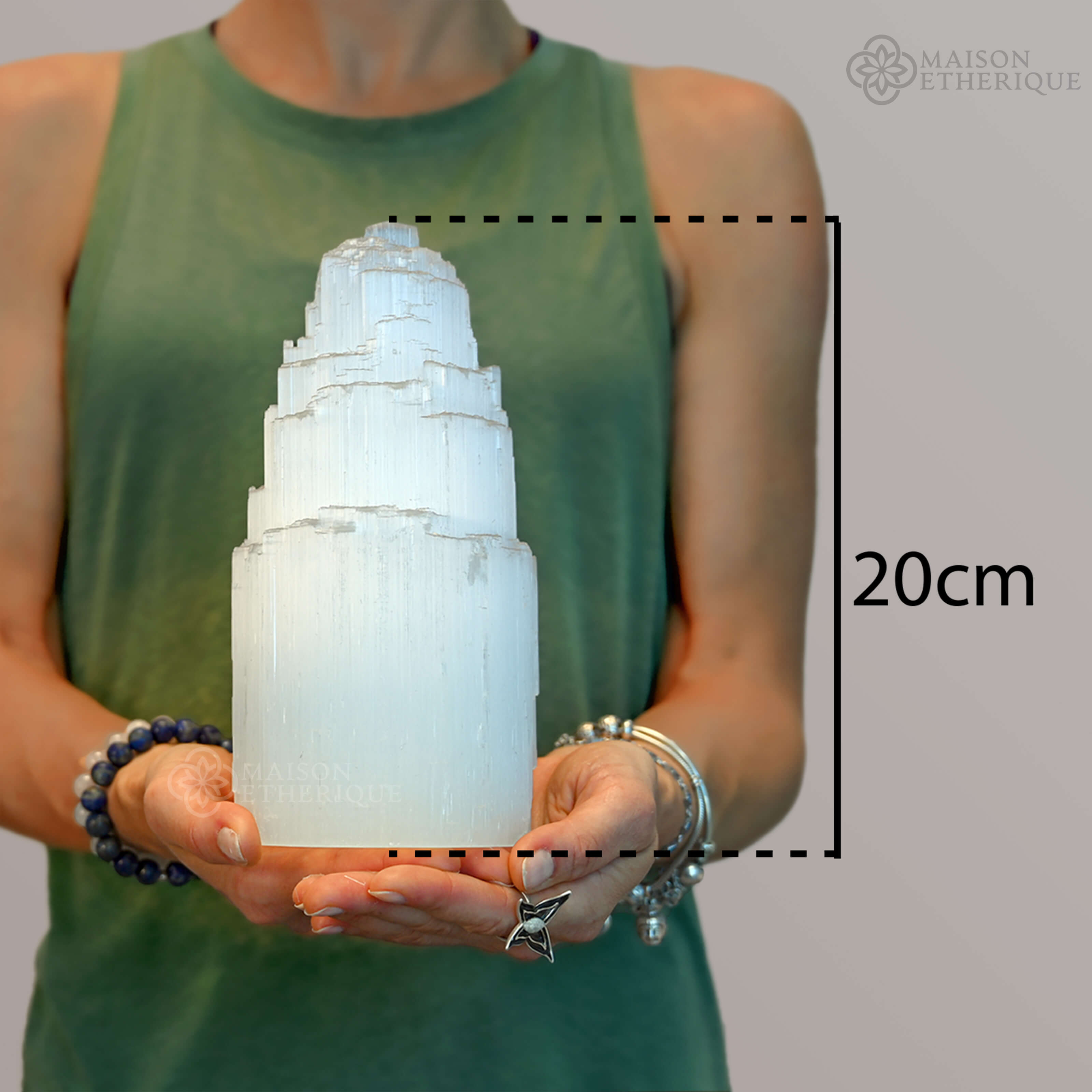 A woman holding A Selenite Crystal Tower - 20cm - 